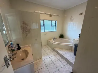 a bathroom with a tub and a sink and a bath tub at Family Home with Big Garden & Jacuzzi in Welgelegen