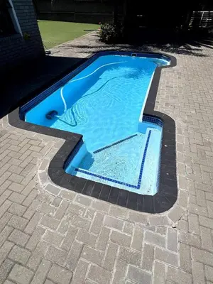 a swimming pool in the middle of a driveway at Family Home with Big Garden & Jacuzzi in Welgelegen