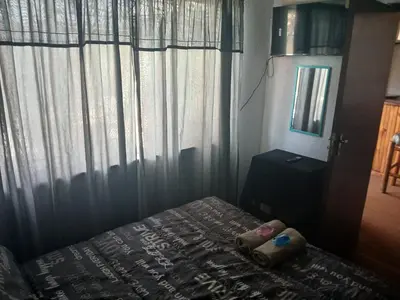 a bedroom with a bed and a window with curtains at Braai and chill getaway in Goodwood