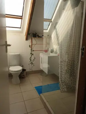 a bathroom with a toilet and a sink and a window at Cozy family home in Cape Town