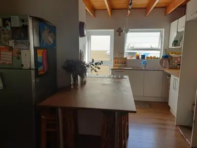 a kitchen with a table and a refrigerator at Cozy family home in Cape Town