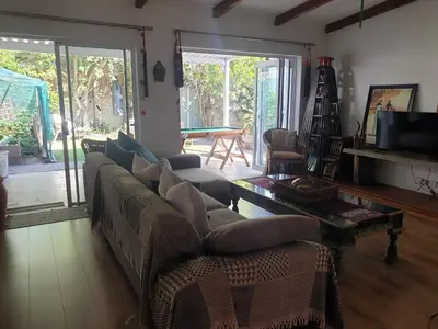 a living room with a couch and a table at Cozy family home in Cape Town