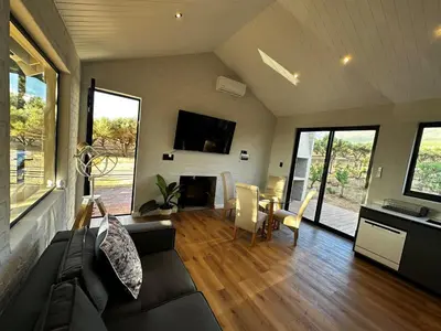 a living room with a couch and a table at Genadendaal Vineyard Villa in Paarl