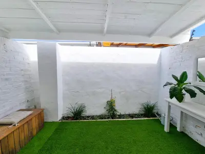 a room with white walls and green grass at Northcliff House in Hermanus