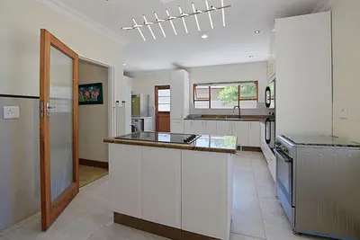 a kitchen with white cabinets and a counter top at Briza Breeze in Cape Town