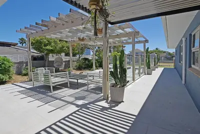 a pergola with benches and a cactus on a patio at Briza Breeze in Cape Town