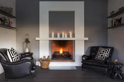 a living room with two chairs and a fireplace at La Providence in Franschhoek