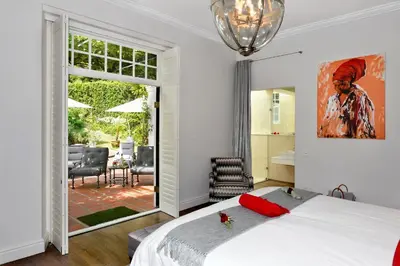 a bedroom with a bed and a large window at La Providence in Franschhoek