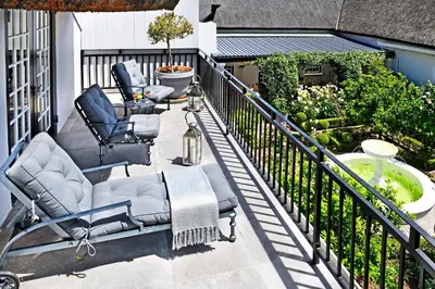 a balcony with two chairs and a tub at La Providence in Franschhoek