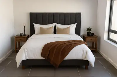 a bedroom with a large bed with a black headboard at Majestic Mountain views in the Cape Town Winelands in Stellenbosch