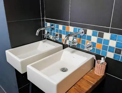 a bathroom with a sink and two faucets at Modern Boho Loft- Observatory in Cape Town