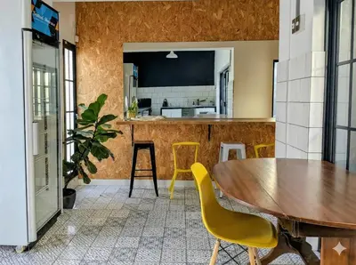 a kitchen with a wooden table and yellow chairs at Modern Boho Loft- Observatory in Cape Town