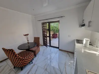 a kitchen with a table and chairs in a room at Bird Retreat in Zeekoevlei