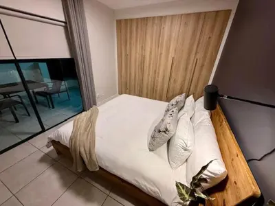a bed with white sheets and pillows in a bedroom at Luxury Coastal Escape in Strand in Somerset West