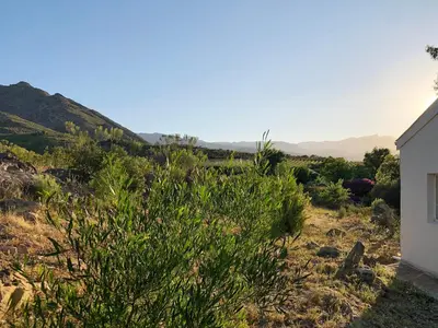 a view from the side of a house with mountains in the background at Eensgevonden Vineyard Cottages in Rawsonville
