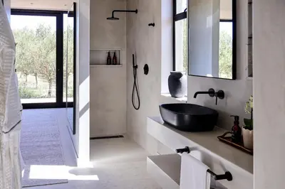 a bathroom with a black tub and a sink at Olijvenkraal Winelands Lodge in Paarl