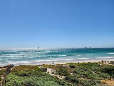 a beach with the ocean in the background at Neptune Isle Oceanfront 3-Bed with Pool in Cape Town