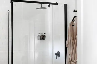 a shower with a glass door in a bathroom at The Farm Cottage in Franschhoek