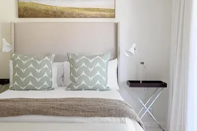 a bedroom with a bed with two pillows at The Farm Cottage in Franschhoek