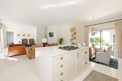 a kitchen and living room with a white counter top at The Farm Cottage in Franschhoek