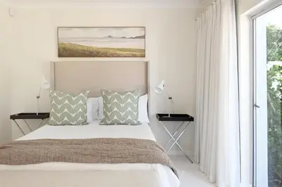 a bedroom with a bed and a large window at The Farm Cottage in Franschhoek
