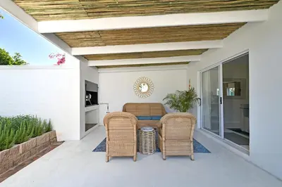 a patio with a table and wicker chairs at The Farm Cottage in Franschhoek