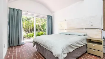 a bedroom with a large bed and a large window at Birdsong in Hermanus