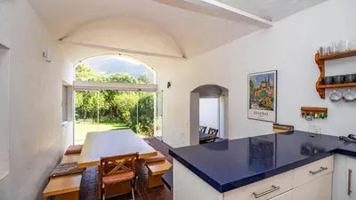 an open kitchen and dining room with a large window at Birdsong in Hermanus