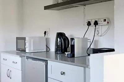 a kitchen counter with a coffee maker and a microwave at The Little Vineyard Cottage in Franschhoek