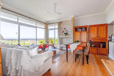 a living room with a couch and a table at 138 Marine Beachfront Guesthouse in Hermanus