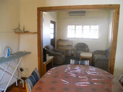 a room with a table and chairs and a living room at Twin Oaks Lodges in Cape Town