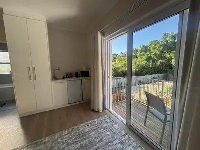 a room with a large sliding glass door with a balcony at Golden Hillside in Somerset West