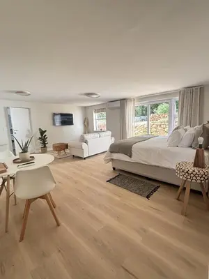 a bedroom with a large bed and a living room at Golden Hillside in Somerset West
