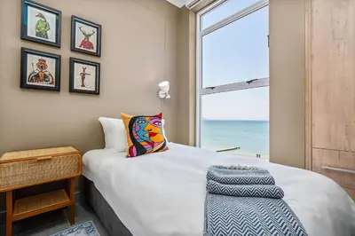 a bedroom with a bed with a view of the ocean at Waves and Wildflowers in Cape Town