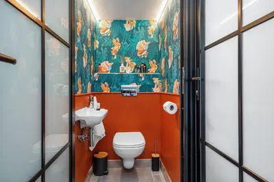 a bathroom with a toilet and a wall mural at Waves and Wildflowers in Cape Town