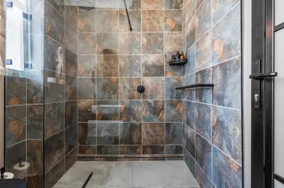 a bathroom with a shower with a glass door at Waves and Wildflowers in Cape Town