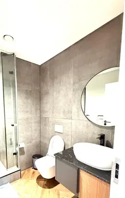 a bathroom with a toilet and a sink and a mirror at Trendy Studio Apartment in On Park in Cape Town