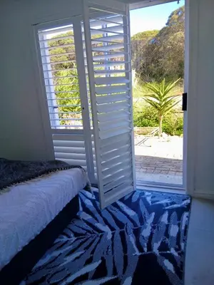 a bedroom with a window with a view of the beach at Providence in Hermanus