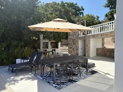 a table and chairs under an umbrella on a patio at Providence in Hermanus