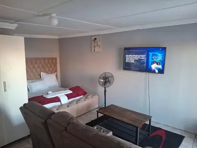 a living room with a couch and a bed at White house apartment in Cape Town