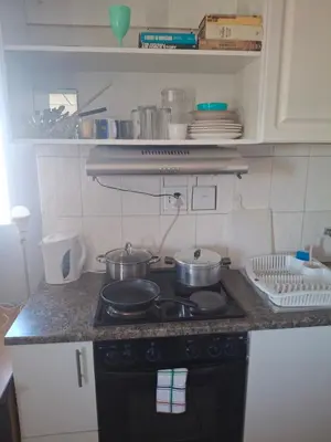 a kitchen with two pots and pans on a stove at White house apartment in Cape Town