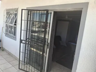 an open door with black bars on a room at White house apartment in Cape Town