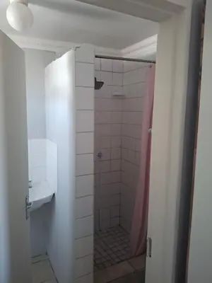 a bathroom with a shower with a pink shower curtain at White house apartment in Cape Town