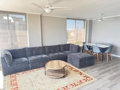 a living room with a blue couch and a table at Odeon Ocean View in Strand