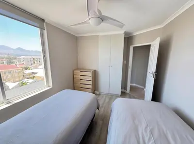 a bedroom with two beds and a large window at Odeon Ocean View in Strand