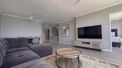 a living room with a couch and a flat screen tv at Odeon Ocean View in Strand