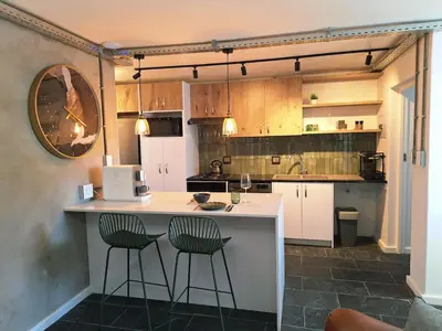 a kitchen with a counter and two bar stools at Green Olive Luxury Stay - Cozy, modern and central in Tygerberg Hills
