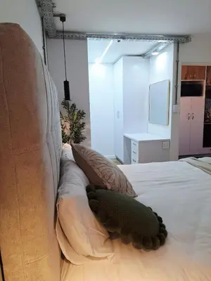 a bedroom with a bed with a couch and a television at Green Olive Luxury Stay - Cozy, modern and central in Tygerberg Hills