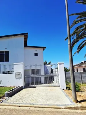 a white house with a gate and a palm tree at Green Olive Luxury Stay - Cozy, modern and central in Tygerberg Hills
