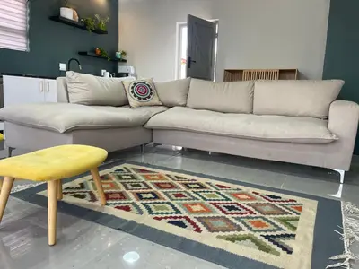 a living room with a couch and a yellow stool at Blouberg kiters in Cape Town